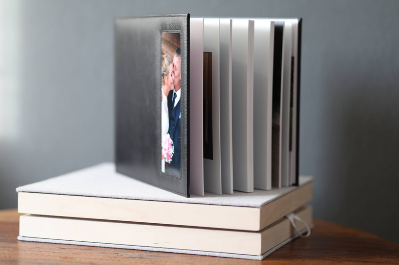 Álbum de boda abierto sobre dos cajas personalizadas